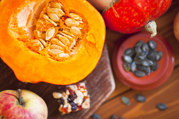  Set of pumpkins, apples and nuts with maple leaves on the wooden background. Autumn mood. Thanksgiving concept. Healthy food, diet, lifestyle and holiday theme. Top view. Close up.