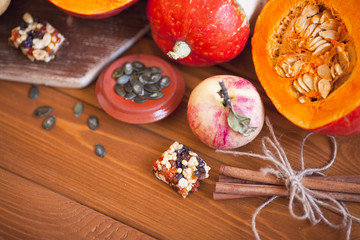 Obraz na płótnie Canvas Set of pumpkins, apples and nuts with maple leaves on the wooden background. Autumn mood. Thanksgiving concept. Healthy food, diet, lifestyle and holiday theme. Top view. Close up.