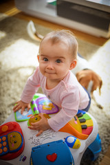 Fototapeta premium Baby girl stands next to cafe table in living room