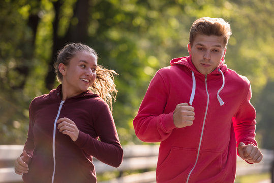 young couple jogging along a country road