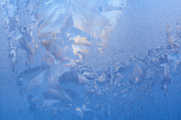 Fine blue frosty icy pattern with different structure on frozen winter glass.
