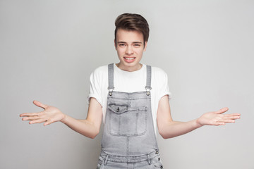 I don't know. Portrait of doubtful young brunette man in casual style with white t-shirt and denim...