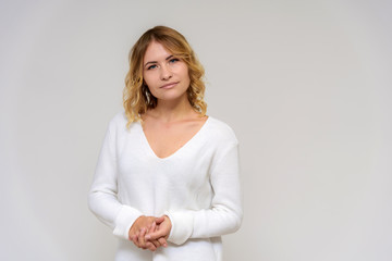 Fototapeta premium Portrait of a beautiful blonde girl on a white background in a dress.