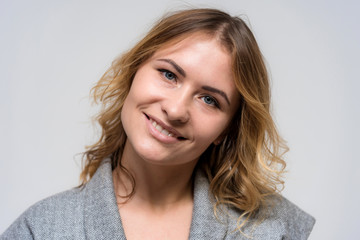 Fototapeta premium Portrait of a beautiful blonde girl on a white background in a dress.