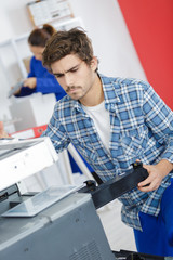 man servicing photocopier