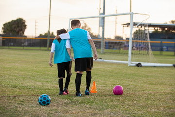 Team mates embrace on a soccer field.