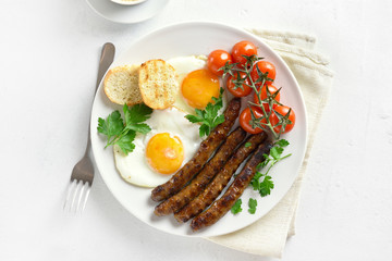 Fried eggs, sausages and cherry tomatoes