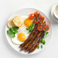 Fried eggs, sausages and cherry tomatoes