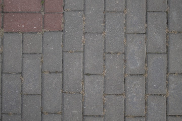 the texture of gray pavers, tiles with a red square