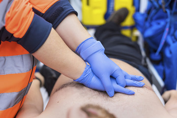 Emergency doctor resuscitate a patient in ambulance. CPR resuscitation.