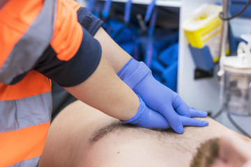 Emergency doctor resuscitate a patient in ambulance. CPR resuscitation.