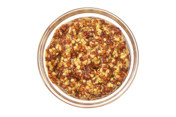 Dijon mustard sauce in glass bowl, top view, isolated on white background.