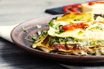 Vegetable lasagne served on ceramic plate - italian cuisine - vegetarian diet. Extreme closeup.