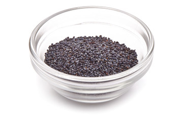 Poppy seeds in a glass bowl, close-up, isolated on a white background.