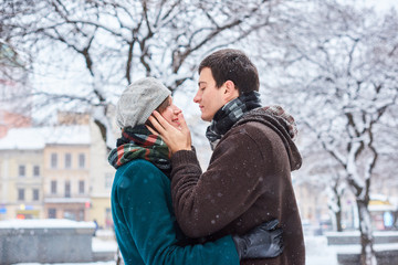 Fototapeta na wymiar Happy couple playful together during winter holidays vacation outside in snow park