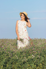 Beautiful young woman on the field of clover