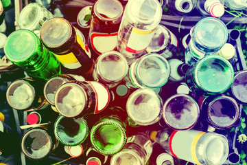 Empty glass bottles stand in a plastic box, top view, vintage toning