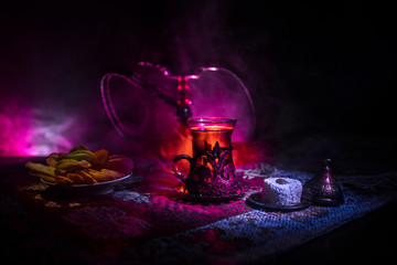 Hookah hot coals on shisha bowl making clouds of steam at Arabian interior. Oriental ornament on...