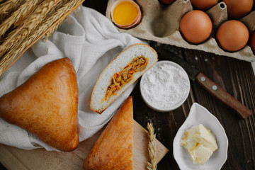 Still life with cabbage pies on a dark background