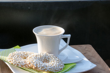 dampfendes Getränk in weißer Tasse mit Keksen
