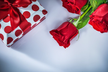 Present box red roses on white background