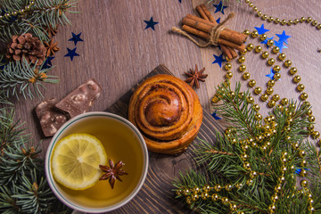 Tea with fragrant pastries on a wooden background with Christmas-tree decorations