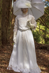 Fototapeta premium Edwardian woman holding a parasol in a garden