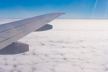 the view from the airplane window at the clouds over the land