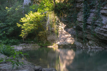 Obraz premium spots of light on a rock above a mountain river Creek, Caucasus mountains, Russia