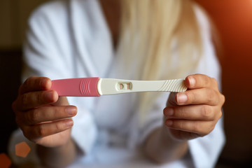 Close up of woman hand holding a positive home pregnancy test