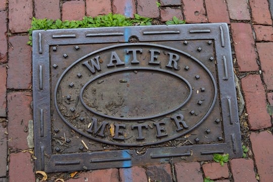 Water meter sign on sidewalk
