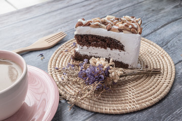 Chocolate with Macadamia-Almond cake Cake and hot coffee in pink cup on wooden table background.