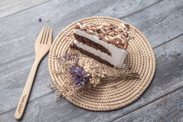 Chocolate with Macadamia-Almond cake and dry flower on table background.