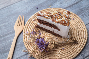 Chocolate with Macadamia-Almond cake and dry flower on table background.