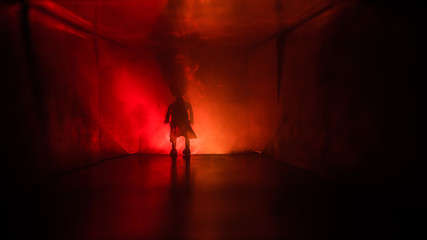 Creepy silhouette in the dark abandoned building. Horror about maniac concept or Dark corridor with cabinet doors and lights with silhouette of spooky horror person