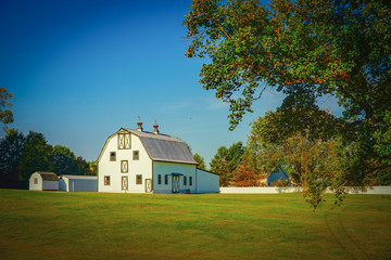 A white barn landscape on a grassy rural farm in North Carolina.