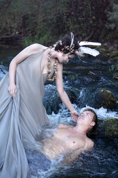 mermaid and a guy lying in the water of a river, maybe she saved him, maybe she wants to drown him, or just seduces him