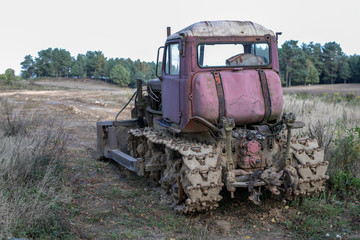 An old bulldozer for leveling the ground. Equipment for earthworks on a guarded field.
