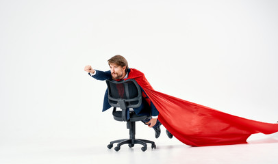 man riding on a chair in a red raincoat hero superman