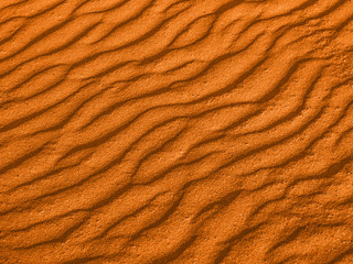 Fototapeta na wymiar texture of yellow red sand waves on the beach or in the desert. the ripples of the sand is diagonal.