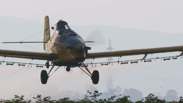 Crop duster spraying chemicals over a cotton field - slow motion