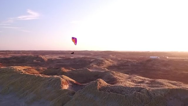Drone/Aerial shot of a parapenter flying over the duns ot the Netherlands. Shot was made by a professional drone pilot.