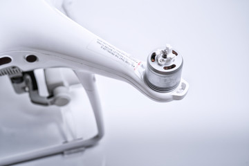 A white drone propeller arm with a rigid type of propeller forward on white isolated background