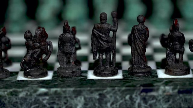 ancient marble chessboard with teal bronce knights as pawns slider macro