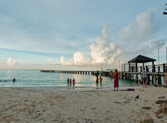 Tropical beach, bathers and wooden pier, Playa Caracol, Boulevard Kukulcan, Zona Hotelera, Cancún, Mexico, in September 8, 2018