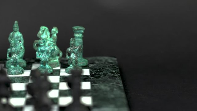 ancient marble chessboard with teal bronce knights as pawns slider macro