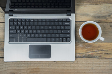 Computer laptop with cup of tea