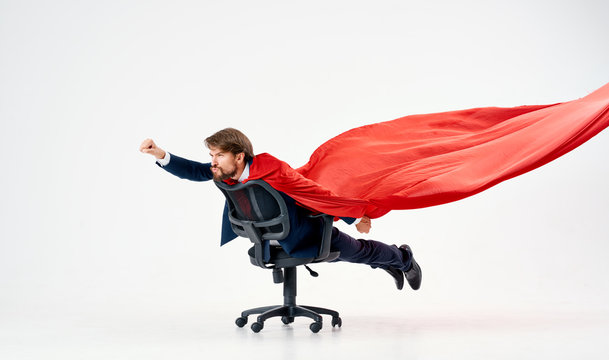 a man in a red raincoat riding a chair a superman business hero