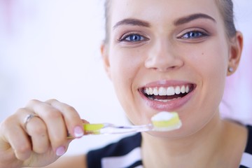 Young pretty girl maintaining oral hygiene with toothbrush.