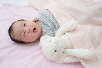 4 weeks old newborn baby wrapped in grey blanket